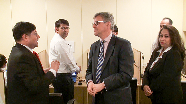 Dr. Paramesh Banerji is giving information to His Excellency about the administrative team while Sukanya Dutta looks on.